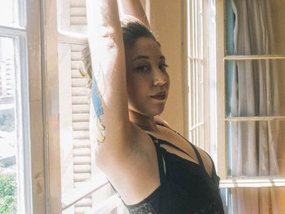 Person stretching their arms towards the bright morning sun.